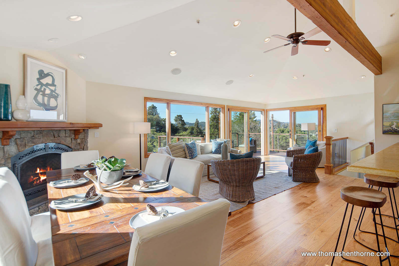 Dining and living area with fireplace and glass doors to outside deck