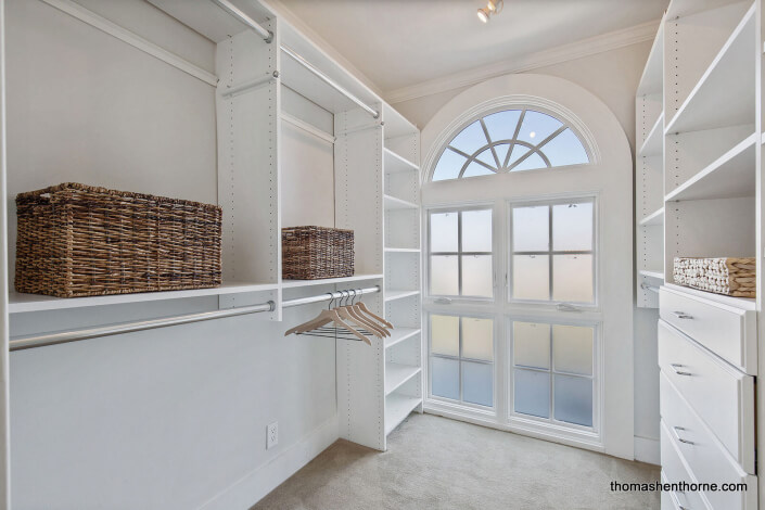 walk-in closet with arched window