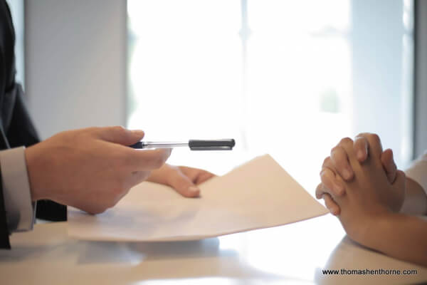 Person about to sign a contract for sale of their home
