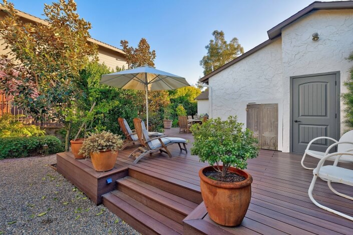 Deck with two chaise lounges and steps down to gravel path