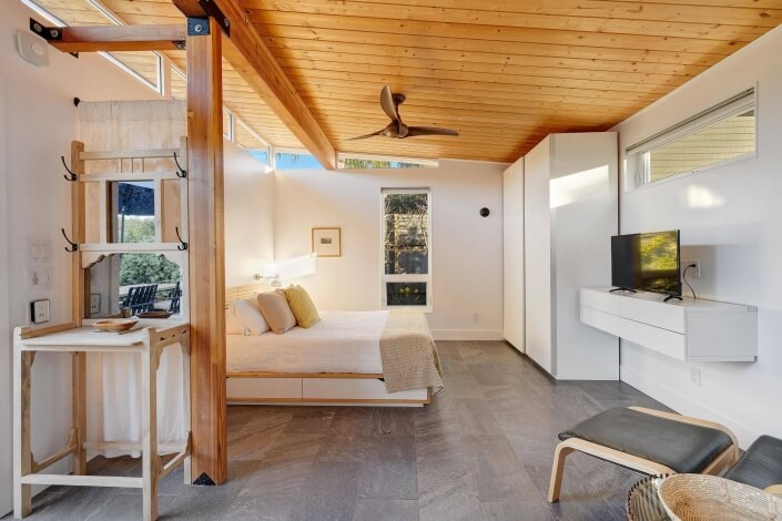 Bedroom area with wardrobe against wall and ceiling fan