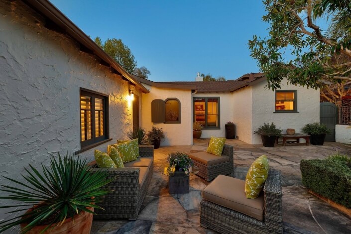 Entry courtyard at dusk with outdoor sofa and chairs