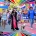 Diverse group at San Francisco Pride with Ukraine flag, banners “EUROpe for LIGHTS” & “QUEER JOY IS RESISTANCE,” dog, rainbow frame.
