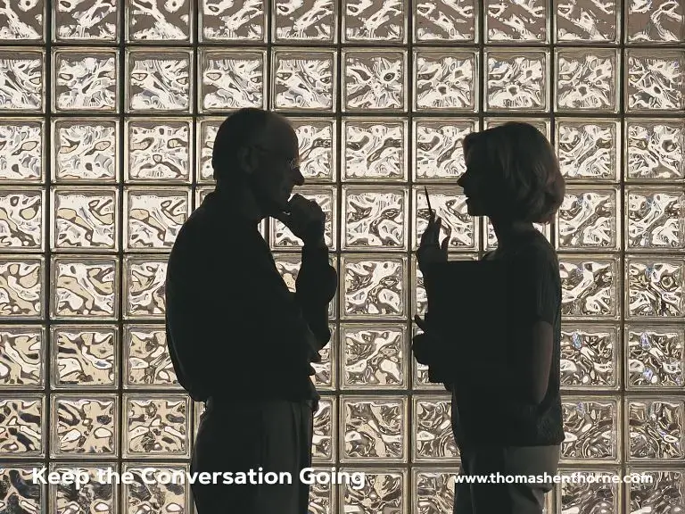 Two people in silhouette stand facing one another, engaged in a thoughtful conversation before a wall made of glass bricks. Text overlaid reads: “Keep the Conversation Going www.thomasethorne.com.”.